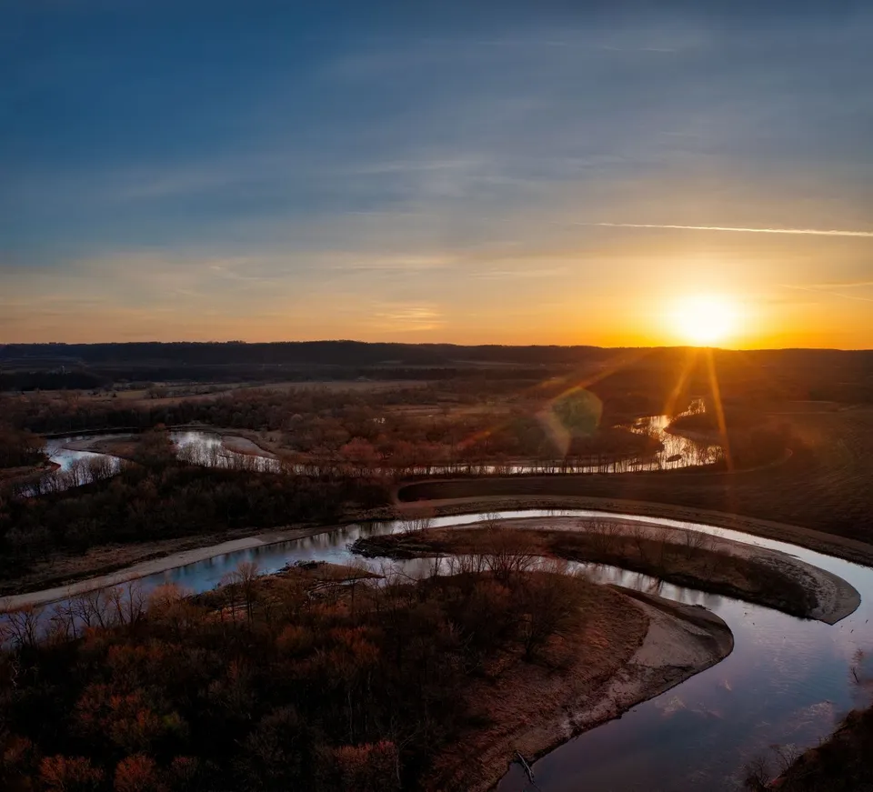 Stunning sunset over a meandering river in Minnesota, captured from above, showcasing natural beauty.