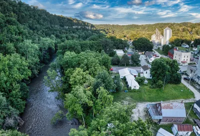 A picturesque aerial view of Lanesboro, MN, showcasing lush greenery and a flowing river.